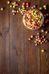 Colorful popcorn in paper box on wooden background top view copy space