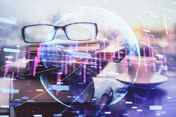 Financial graph hologram with glasses on the table background. Concept of business. Double exposure.