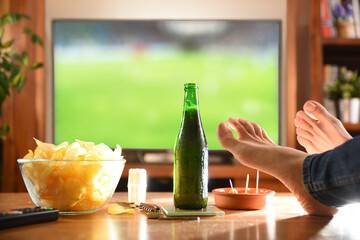 Watching match on tv with appetizer on table