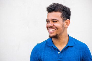 horizontal front portrait smiling young mixed race man with beard against white background looking...