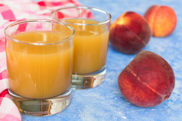Fresh peach juice in a glass on a blue background.Close-up.