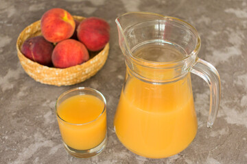 
Jug of peach juice on a gray background. View from the top.