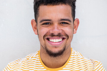 Close up smiling young african american mixed race man with beard against white background