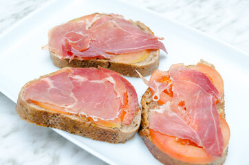 slices of bread with tomato and ham close up