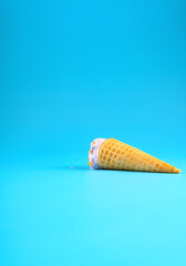 sweet potato flavor ice cream cone in a melting process on blue background vertical composition