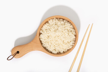 Fototapeta na wymiar Cooked rice in wooden spoon and chopsticks on white background. Top view