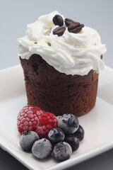 Chocolate chip muffin with whipped cream and berries