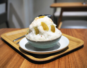 Preserved or pickled or compote madan kakigori, the shaved ice with sliced preserved madan served with mixed sugar, salt and hot chili powder for more tasty. Trendy dessert in Thailand.