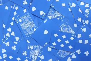 Mixed playing cards background. Assorted play cards backdrop. Many miscellaneous jumbled blue...