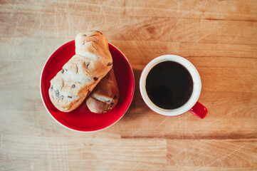 Top view of black coffee and croissant on a wooden board