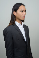 Young Asian businessman with long hair thinking