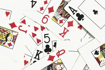 Many miscellaneous jumbled playing cards surface. Mixed playing cards background. Assorted play...