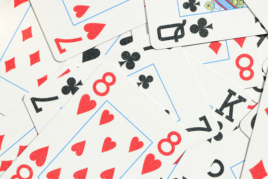 Mixed playing cards background. Assorted play cards backdrop. Many miscellaneous jumbled playing cards surface.
