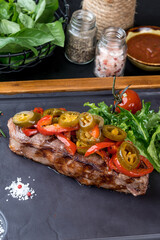 Grilled steak served on a black slate board