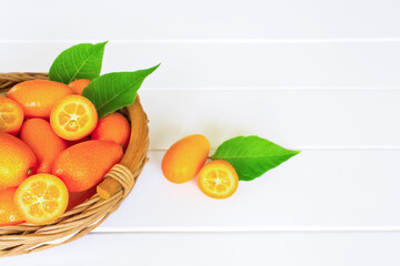 ripe kumquat fruits in a wicker basket on a white background close-up. background with kumquat fruits.