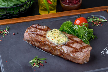 Grilled steak served on a black slate board