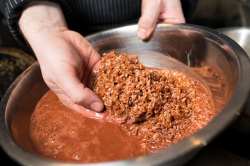 Step-by-step process and stages of cooking oriental cuisine - pilaf. The cook is washing rice for pilaf
