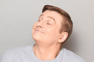 Naklejka premium Portrait of funny happy man dreaming about something pleasant
