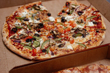 vegetarian pizza with olives and eggplant in a cardboard box