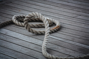Thick rope coiled on a wooden floor.