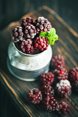 Frozen blackberries on a wooden table. Vertical.