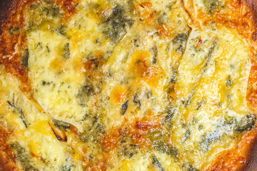 Quattro Formaggi/Four Cheese Pizza on a wooden pizza board. Close Up pizza cheese: blue cheese, parmesan, mozzarella, gorgonzola. Concept of homemade pizza with free space for your text/decoration. 