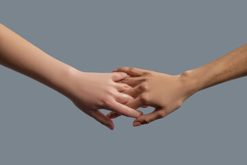 Close-up of people from different races interlocking fingers