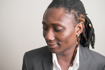 Face of young handsome African businessman with dreadlocks thinking and looking down