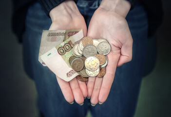 Russian money on the palm of a woman. paper money and iron coins