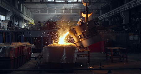 Smelting orange metal in a metallurgical plant. Liquid iron from the ladle
