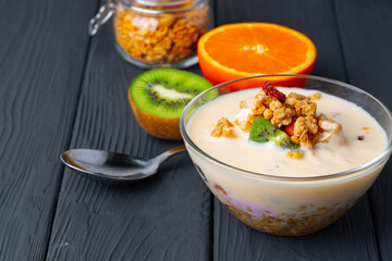 Bowl of granola with youghurt and sliced fruits