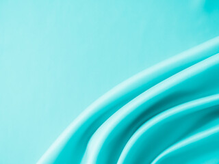 Beautiful elegant wavy turquoise silk or satin luxury cloth fabric texture, abstract background design.