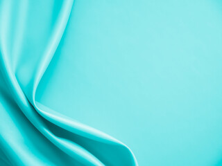 Smooth elegant wavy turquoise silk or satin luxury cloth fabric texture, abstract background design.
