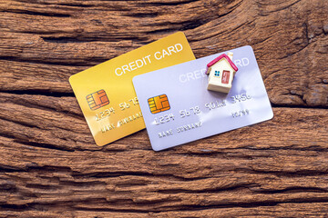 demo credit card and miniature home on wooden background