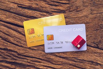 demo credit card and miniature home on wooden background