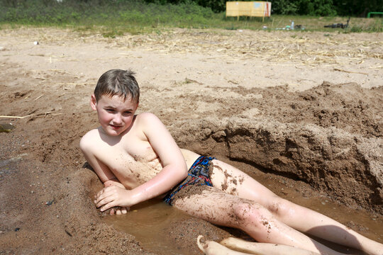 Child lying on sandy beach