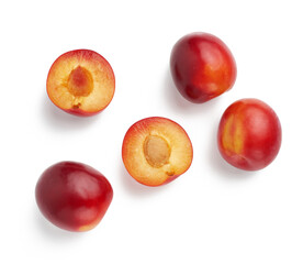 ripe red whole and halves of plum isolated on white background