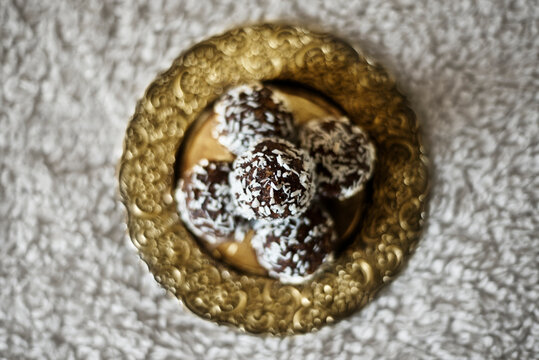 A Top Down View Of A Stack Of Chocolate Balls On A Golden Plate