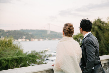 Couple watching the view. Both of them overlook the Bosphorus Bridge.