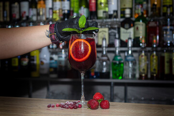 A refreshing summer cocktail with a slice of orange. Aperol alcoholic drink. Decorated with a sprig of mint and ice cubes.