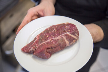 Rohes Steak auf weißem Teller in der der Küche