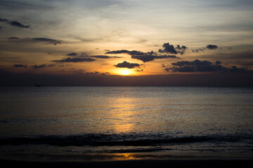 Fototapeta na wymiar Sunset over the sea seen from a beach in Koh Lanta, Thailand