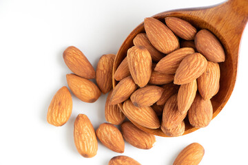 Almonds on wooden spoon isolated over white background