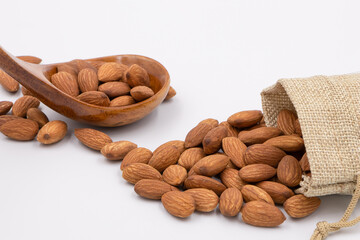 Almonds in a cloth bag and a wooden spoon separated the leg background