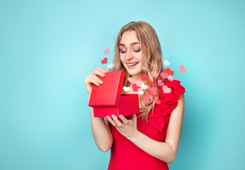 Beautiful woman holding gift on blue background