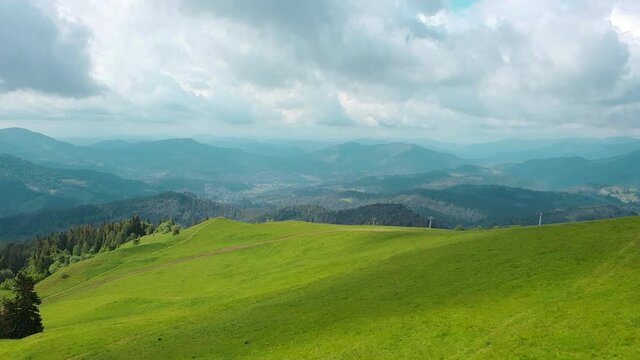 Aerial Drone View mountains covered with green grass and green trees. View of the mountain tops covered with dense forests. Fabulous view of the Carpathian mountains in Ukraine.