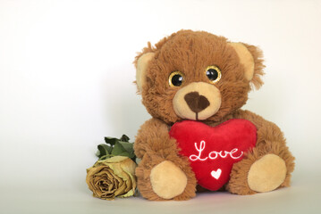 teddy bear with a heart and a dried rose