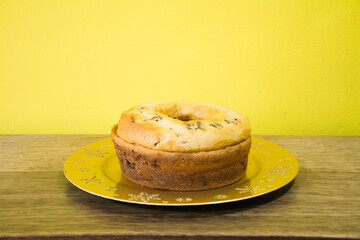 Tingling cake with chocolate on golden tray on yellow background and chocolate sprinkles