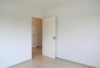 Fototapeta premium Open door in the white room of new house