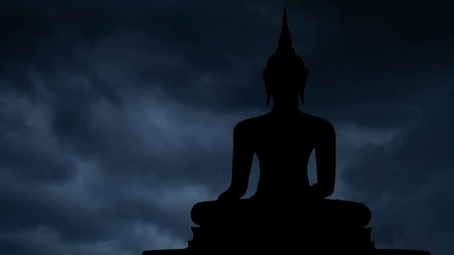 Buddhism: Lightning and Thunderstorm flash over the Silhouette of Ancient Sculpture of Buddah, Bangkok, Thailand